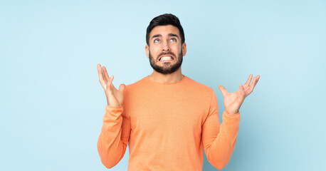 Fototapeta premium Caucasian handsome man stressed overwhelmed over isolated blue background