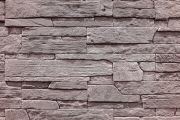 The wall is made of multi-layered natural stone. Stone for building a house.