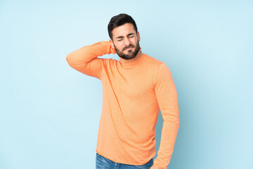 Caucasian handsome man with neckache over isolated blue background