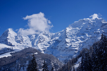 Fototapeta na wymiar Panorama of Bernese Alps with Mountain Peaks Eiger, Mönch (monk) and Jungfrau (virgin), seen from Mürren, Switzerland.