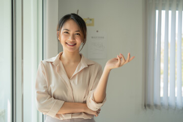 Pleased Asian businesswoman with crossed arms looking at the camera.