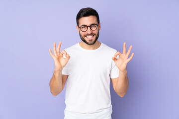Caucasian handsome man over isolated background showing ok sign with two hands