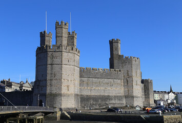 The  historical motte and bailey castle viewed from across the river in Caernarfon, Gwynedd, Wales, UK. 