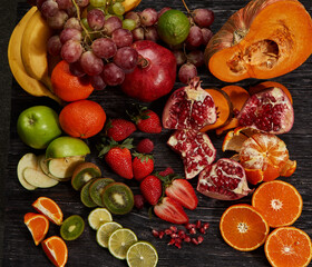 Top view of fresh multicolor fruits and vegetables on dark old wood. Different fruits and vegetables for eating healthy.