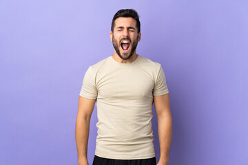 Young handsome man with beard over isolated background shouting to the front with mouth wide open