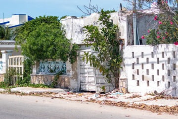 View from the street of a humble fishing village, with gates hanging askew 