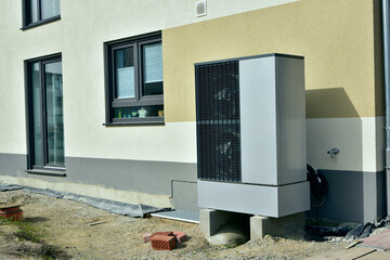 Luftwärmepumpe/Klimaanlage für Heizung und Warmwasser vor einem Wohnhaus