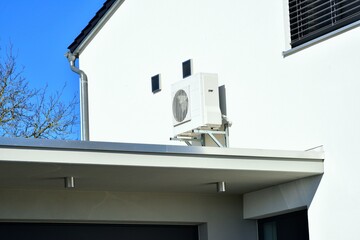 Luftwärmepumpe/Klimaanlage für Heizung und Warmwasser vor einem Wohnhaus