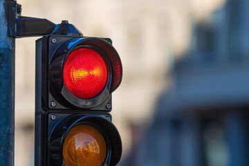 close-up of traffic semaphore with red light on defocused city street background with copy space