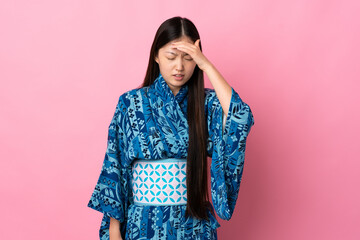 Young Chinese girl wearing kimono over isolated background with headache