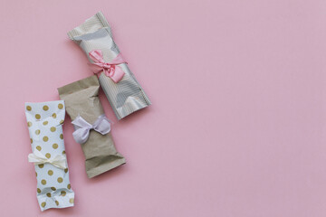 Many of DIY gift boxes on a pink background, not very neat gifts, but made with love