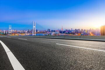 Asphalt highway and city skyline with bridge at dusk in Shanghai,China.