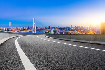 Fototapeta na wymiar Asphalt highway and city skyline with bridge at dusk in Shanghai,China.