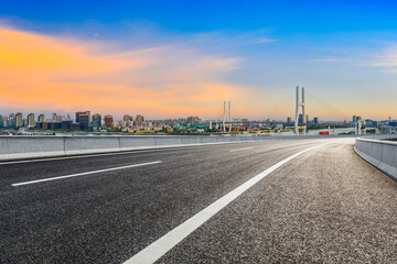 Asphalt highway and city skyline with bridge at dusk in Shanghai,China.