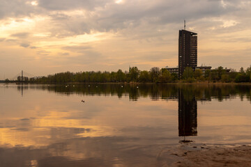 Naklejka premium Dark sunset view to TV building tower at Zakusala, Riga Latvia when sunset, island, tower and bridge are reflecting in river Daugava