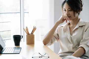 Portrait Young asian businesswoman thinking for work at her office. - Powered by Adobe