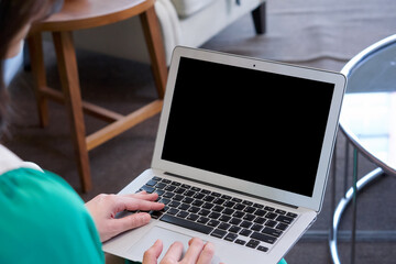 Young woman in green clothes use her finger press on keyboard to waking laptop computer from sleep...