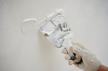Mixer for building mixes in white liquid putty on the background of ready-made material for...