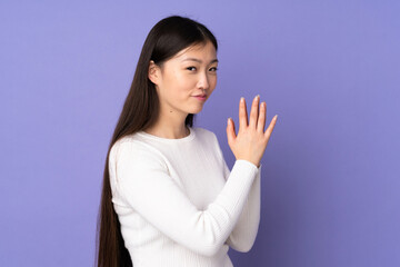 Young asian woman isolated on purple background scheming something