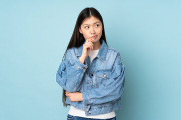 Young asian woman isolated on background having doubts and thinking