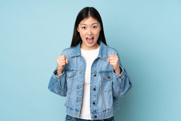 Young asian woman isolated on background celebrating a victory in winner position