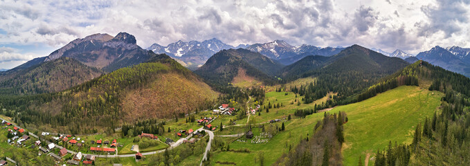 Spring rainy weather mountain panorama. Village in green forest hills. Road from Poland to Slovakia