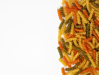 Tricolor, dry and raw pasta on a white background