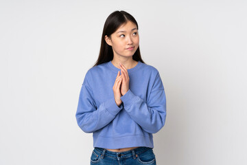 Young asian woman isolated on background scheming something