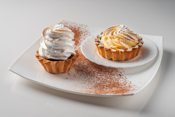 Cake basket with protein cream and cake basket with cottage cheese cream on a white plate sprinkled with cocoa