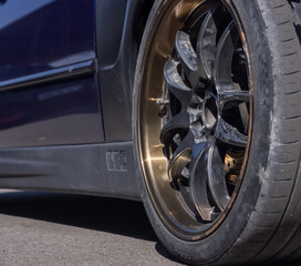 car on the road, car wheel on the road, close up of a sports car wheel