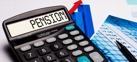 On the calculator display there is an inscription PENSION. Nearby are colored diagrams and graphs. Business concept