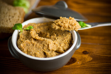 homemade meat pate in a ceramic bowl on a wooden table