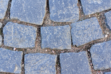 Fragment of an old granite pavement made of square blocks