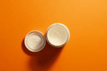white paint in a cup on an orange background