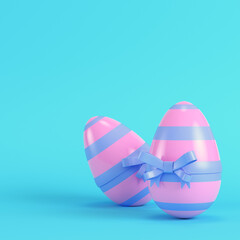 Pink easter eggs with bow on bright blue background in pastel colors