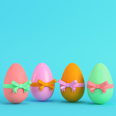 Colorful easter eggs with bow on bright blue background in pastel colors. Minimalism concept
