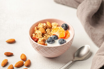 Oatmeal granola with yogurt, berries, fruits and nuts in a bowl on the table. Healthy breakfast