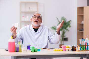 Old male chemist testing soap in the lab