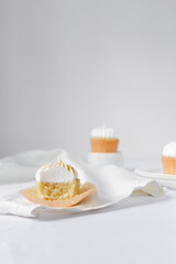 Vanilla cupcake with a meringue frosting, cupcake with a bite taken out it, white frosting on cake