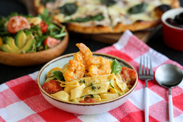 Pappardelle pasta with shrimps.Pasta with shrimps and tomatoes.Italian dishes.Italian homemade pasta with seafood.Pasta with tomatoes and pesto.Spaghetti with shrimp and parmesan.Meal day.Italian food