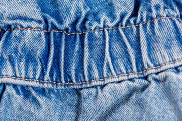 Close-up of blue jeans pocket showing fabric texture and stitching