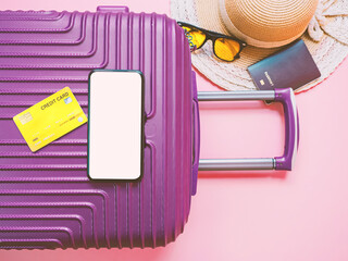 summer travel concept from credit card and suitcase with summer collection on pink background.