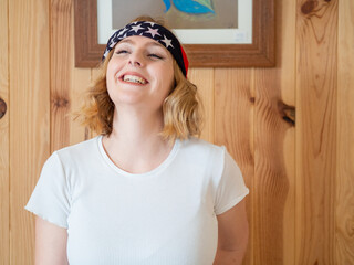 Mujer rubia celebrando el Día de la Independencia de los Estados Unidos en una pared de madera