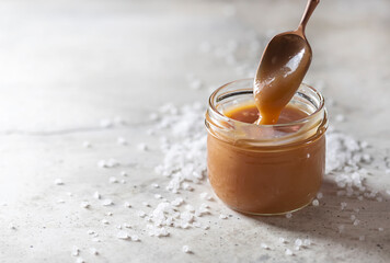 Homemade salted caramel in a glass jar.