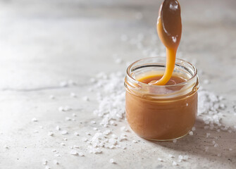 Homemade salted caramel in a glass jar.
