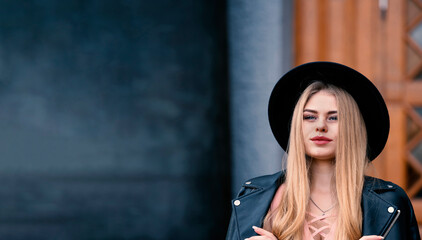 Young beautiful blonde in a black hat. Banner with copy space