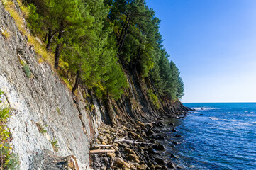 rocky sea shore with pebble beach, waves with foam