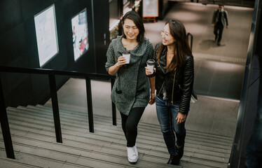 Two japanese women around in Tokyo during daytime. Making shopping and having fun