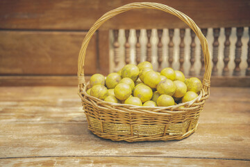 orange tangerine fruit in rattan wicker basket on wooden chair