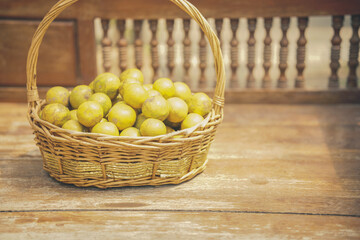 orange tangerine fruit in rattan wicker basket on wooden chair